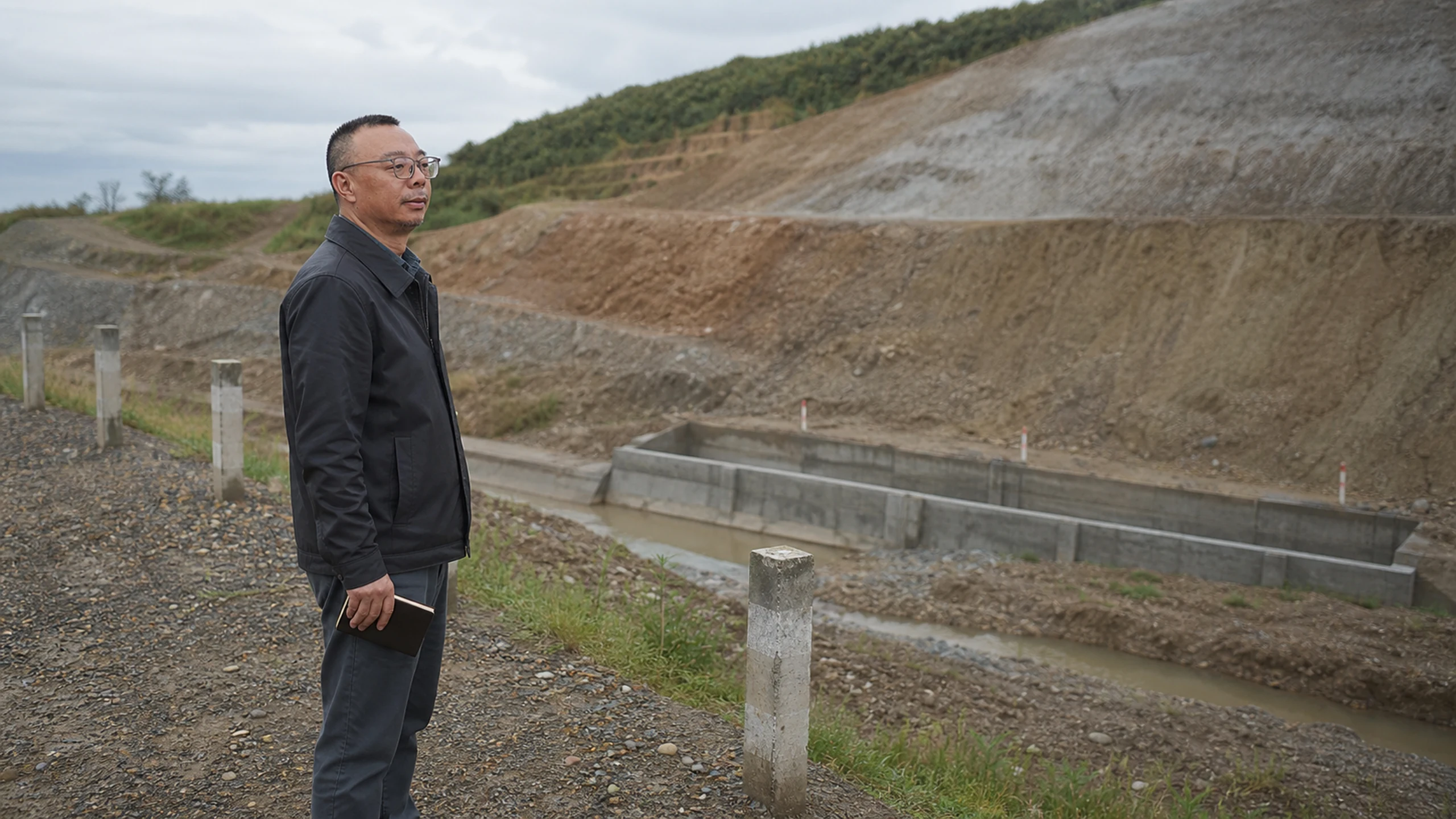 Zhou Zhiyong observing a generic civil earthwork setting